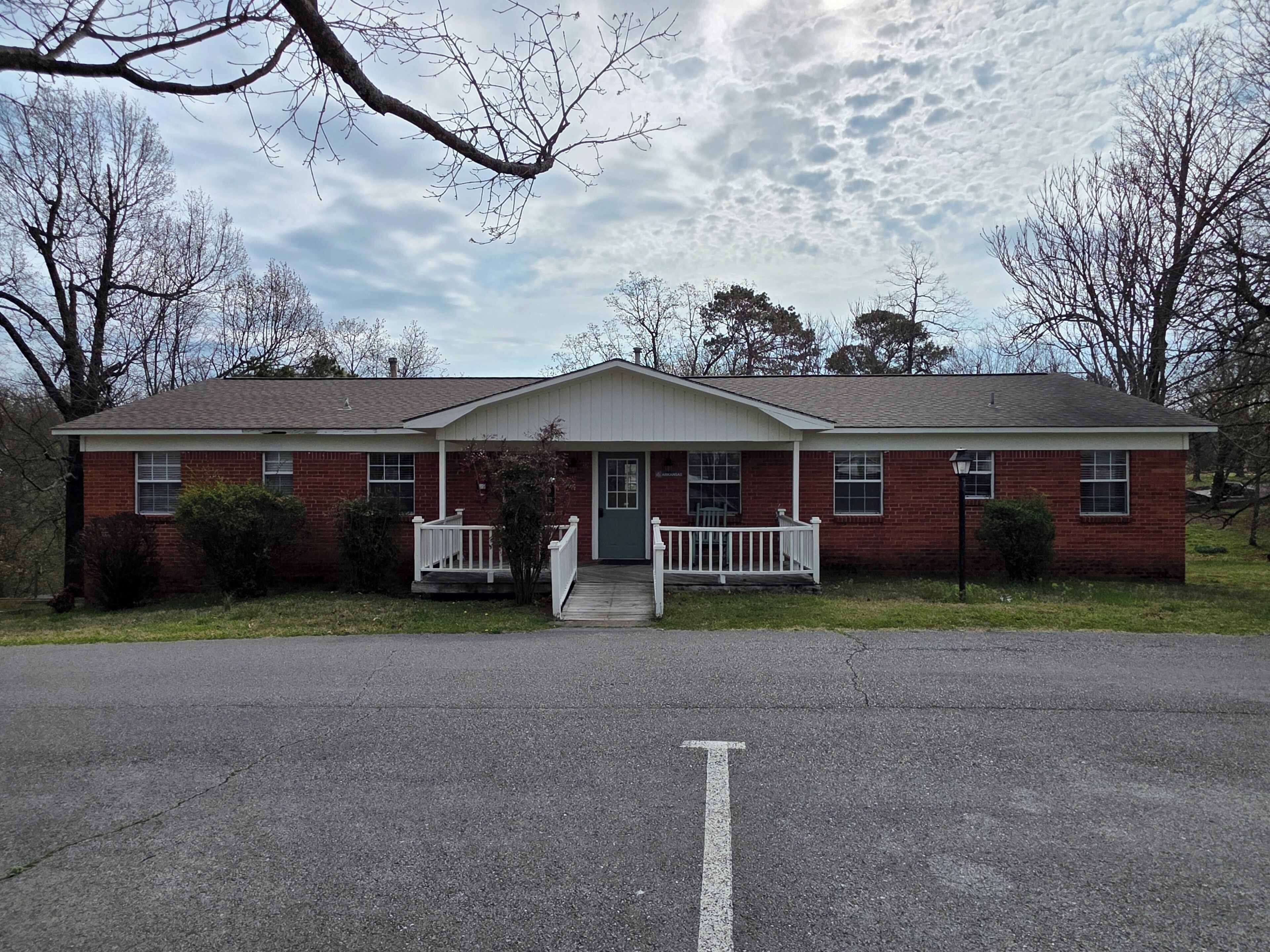A two-story brick house with a front porch, a garage, and a driveway.