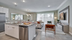 A modern kitchen with a central island, built-in appliances, and a dining area with a sofa and chairs. - Luxury Villa With Private Pool Just 5 min From Disney Parks (Kissimmee)