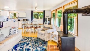 Un salón amplio con chimenea, una mesa de comedor y una cocina al fondo.