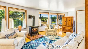 Una sala de estar acogedora con chimenea, ventanas amplias y un rincón de asientos confortable.