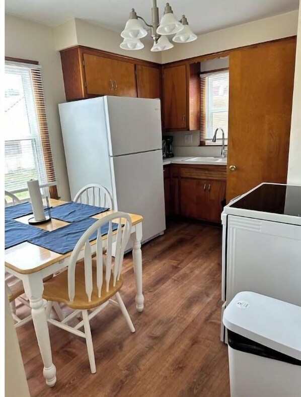 Enjoy meals in this cozy kitchen with a dining table and chairs, sink, and stove.