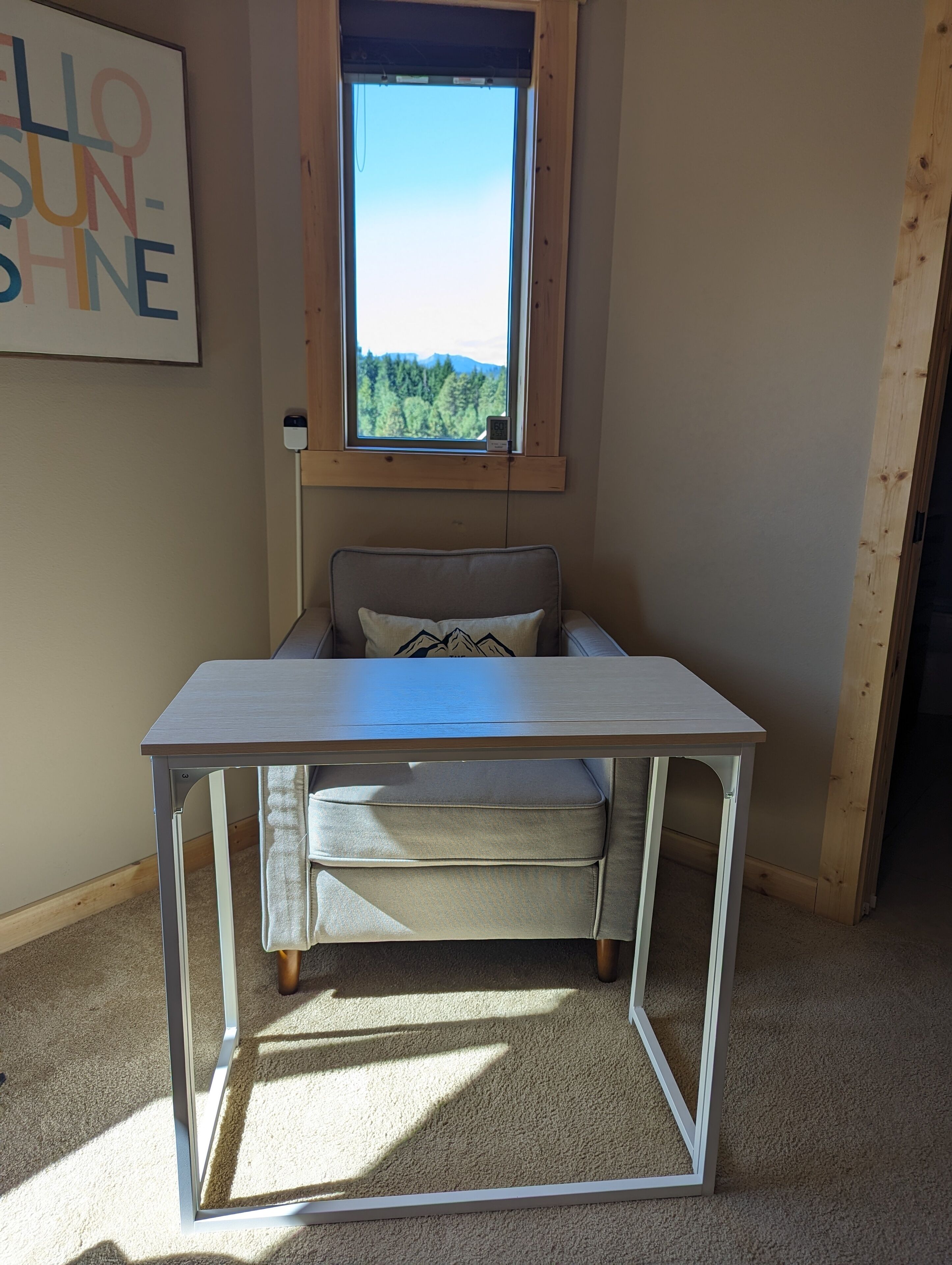 Une pièce avec un lit, une table et une fenêtre donnant sur des arbres.