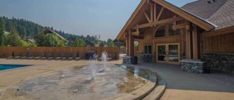 Un chalet doté d’une grande piscine extérieure et d’une fontaine.