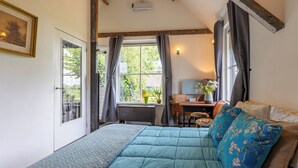 Une chambre à coucher avec un lit, un bureau et une fenêtre avec des rideaux.