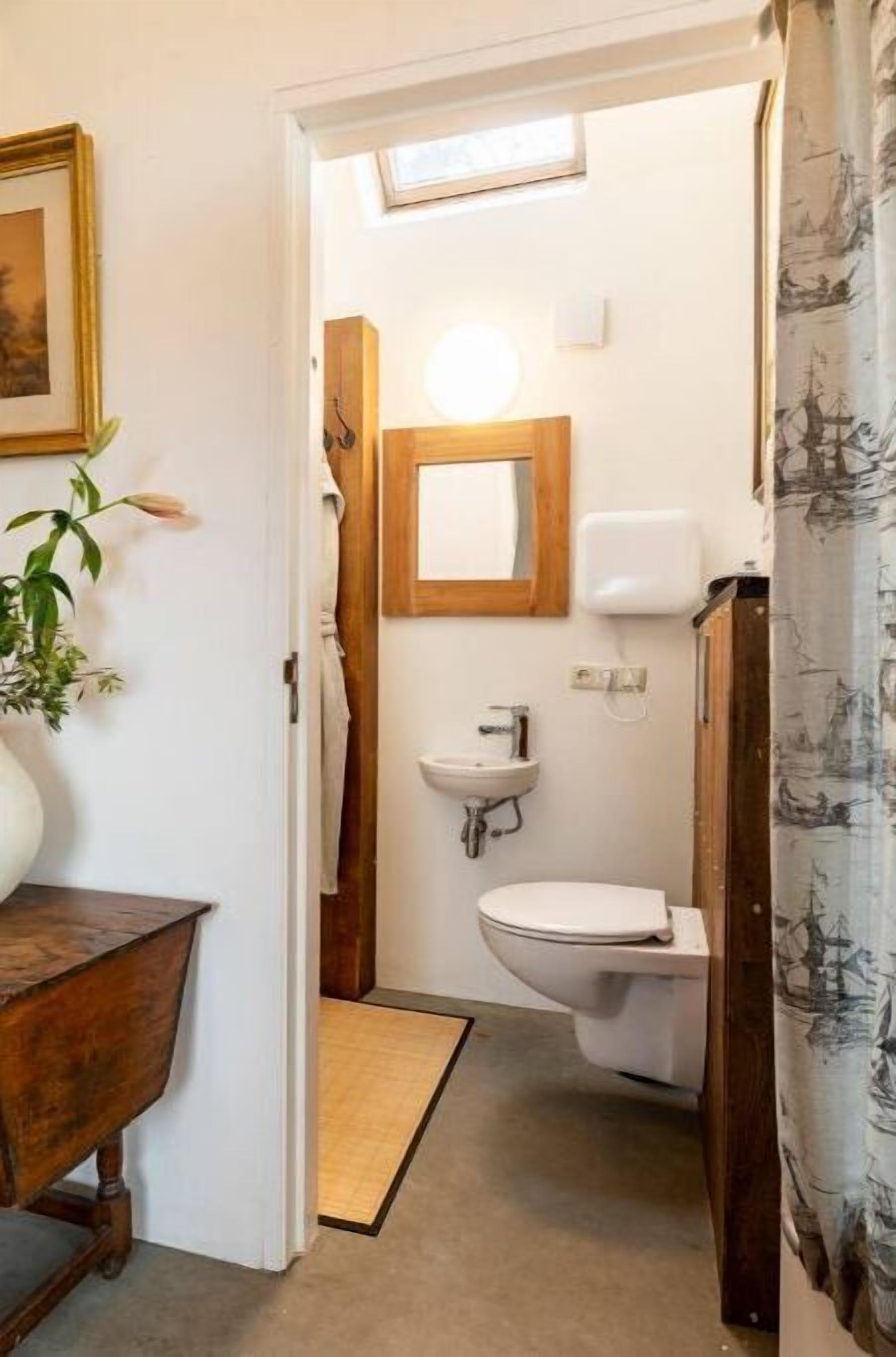 A bathroom with a wooden vanity, a sink, and a toilet.