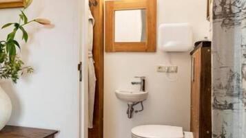 A bathroom with a wooden vanity, a sink, and a toilet.