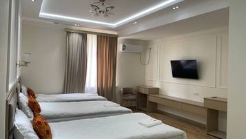 Habitación de hotel con dos camas, televisor, escritorio y silla.