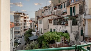 A narrow street lined with multi-story buildings, balconies, and parked cars. - Ariston Centro (Sanremo)