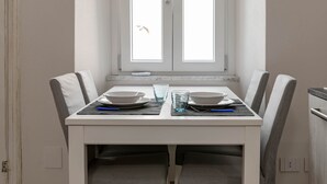 Une table à manger avec deux chaises, une fenêtre et une vue sur l’extérieur.