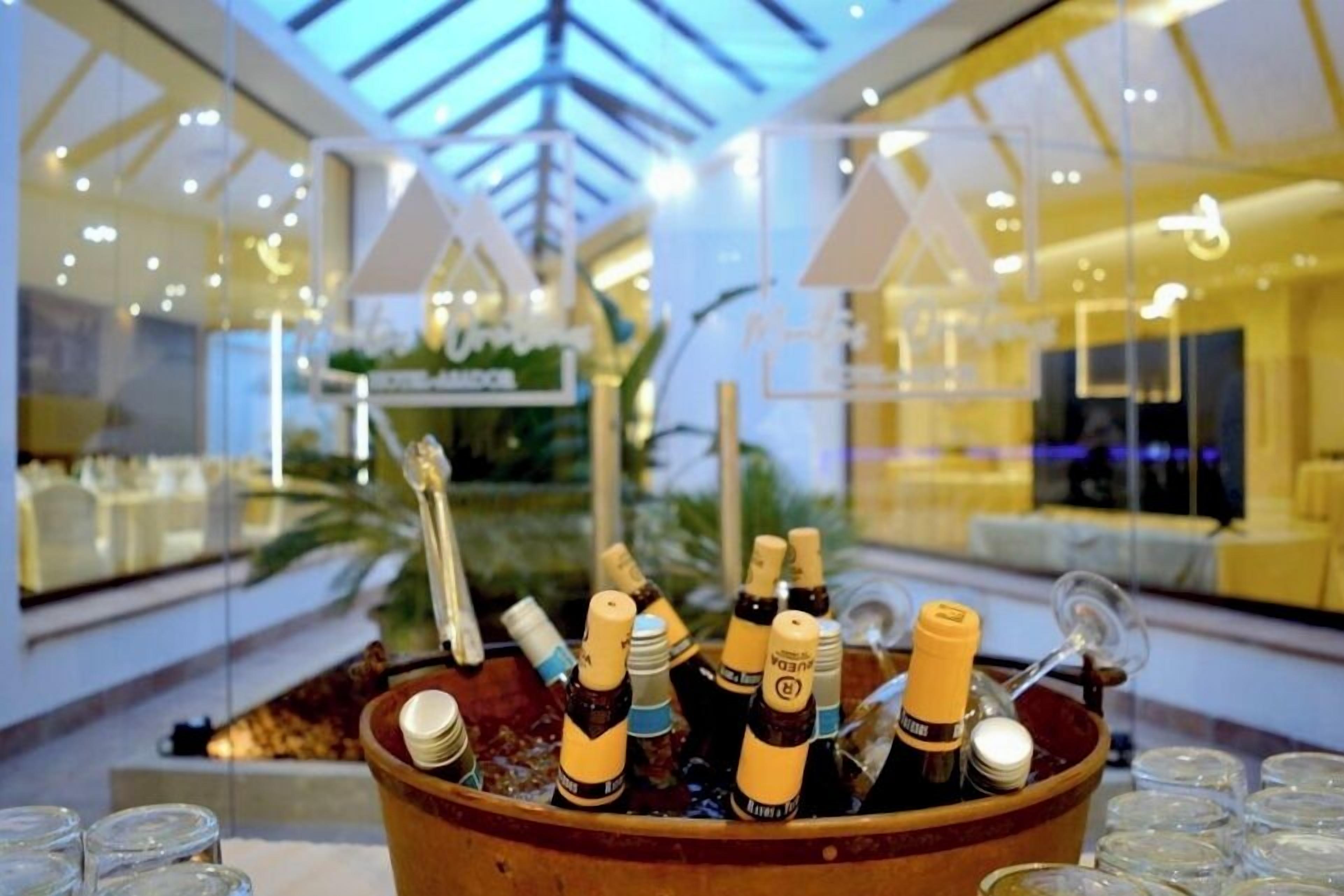 A bar area with bottles of beer and glasses in a wooden container.