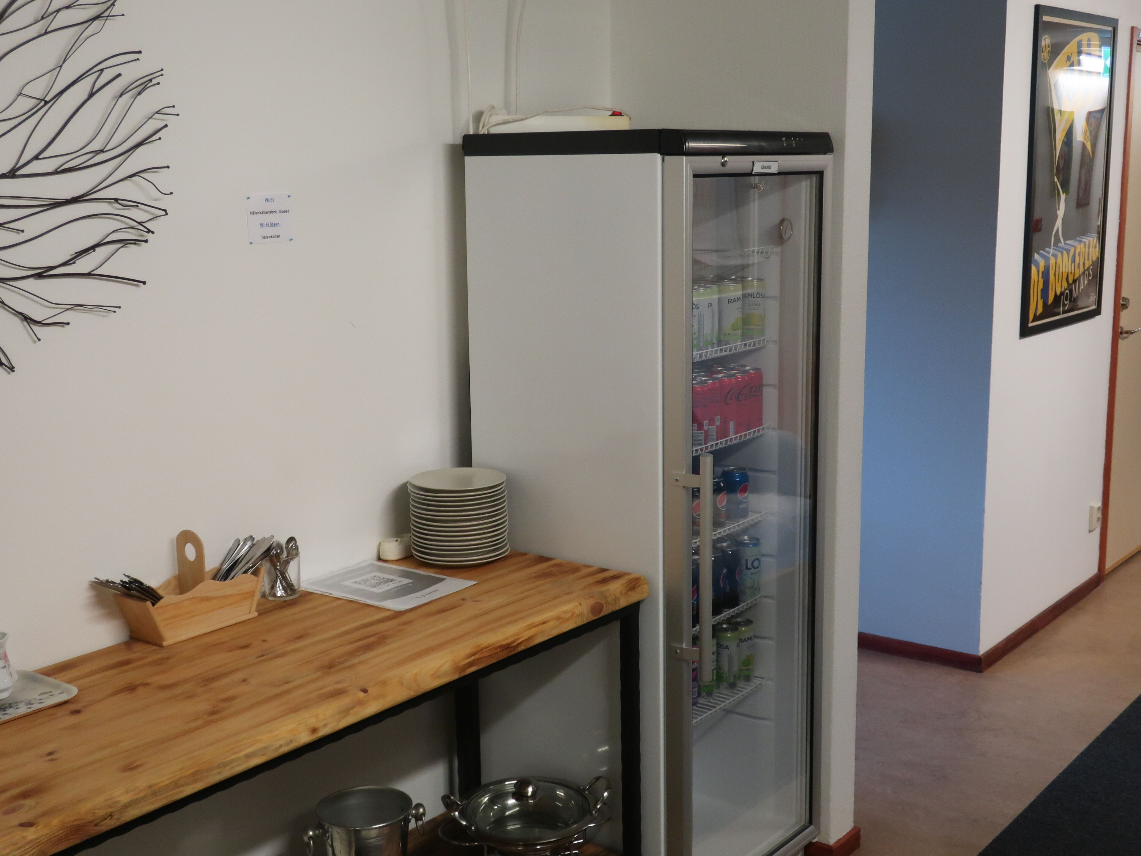 Una kitchenette con refrigerador, mostrador de madera y pileta.