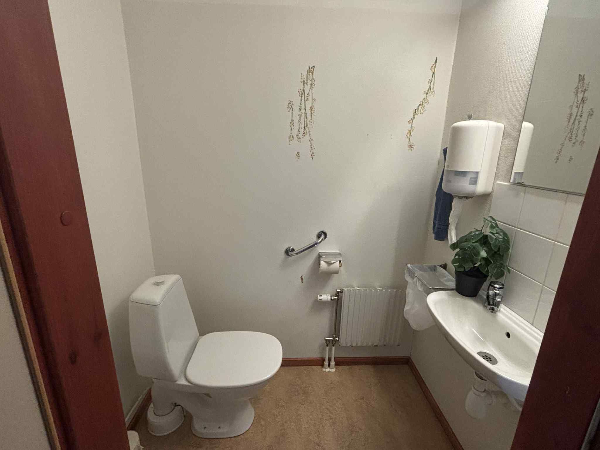 Un baño pequeño y funcional con inodoro, lavabo y radiador.