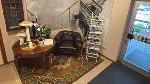 Una habitación con escritorio, una silla, un mapa grande, una estantería y una puerta con vistas al exterior.