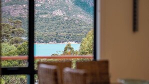 Une vue sur un paysage montagneux avec un lac et une plage, vue à travers une fenêtre.