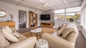 Un salon moderne avec un canapé, une table basse et un téléviseur.