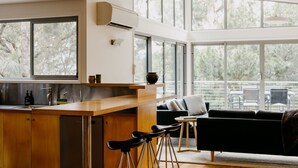 A modern kitchen with a wooden countertop, a built-in sink, and a large window.