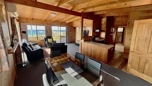 Una cabaña de madera con comedor, sala de estar y cocina.