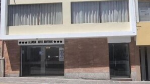 A hotel building with a modern design, featuring a flat roof and large windows. The facade includes a sign indicating the hotel's name and a rating of four stars. - Alsacia Boutique Hotel (Arequipa)