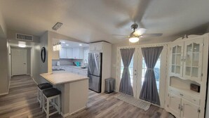 A modern kitchen with a central island, white cabinetry, and a ceiling fan. - Beautiful peaceful quiet country living 

 (Holtville)