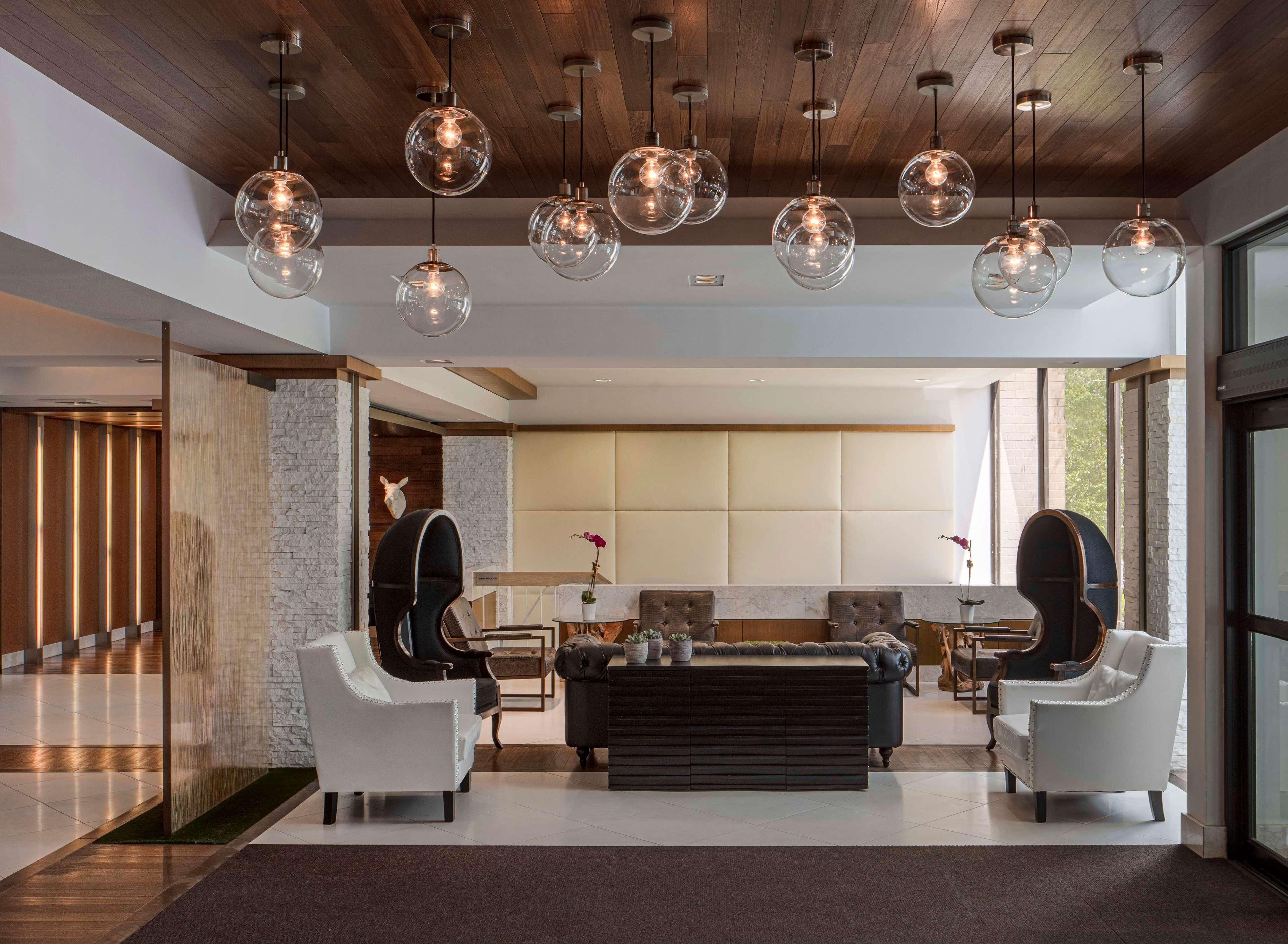 A modern interior with a seating area, a stone accent wall, and a large window.