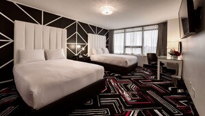 A hotel room with two beds, a desk, a chair, a TV, and a patterned carpet. - Hotel Noma Trademark Collection By Wyndham (New Rochelle)