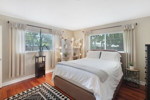 Relax in this serene bedroom with a large bed and a cozy reading nook.