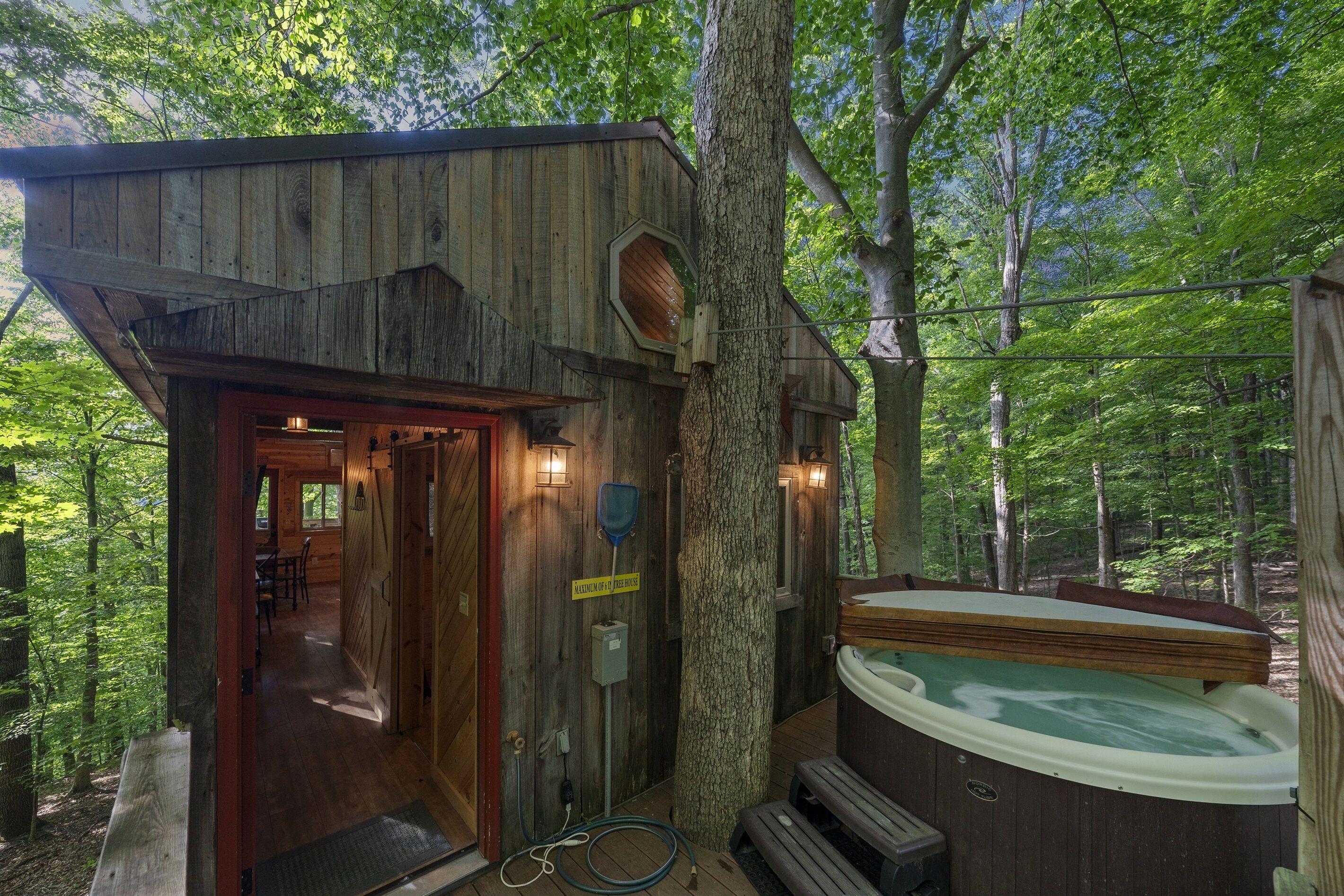 A rustic wooden cabin with a hot tub and a dining area.