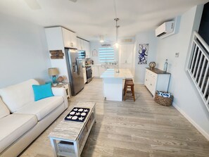 Relax in a spacious living area with a central dining island, sofa, and coffee table, perfect for unwinding.
