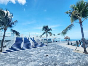 Stroll along the beachfront promenade, where blue-tiled steps lead to a charming building with balconies.