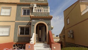 Un immeuble résidentiel doté d’un balcon, d’une antenne parabolique et d’un portail.