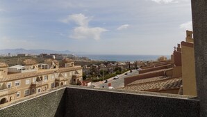 Un paysage urbain côtier avec une architecture traditionnelle, un ciel dégagé et une vue sur la mer.