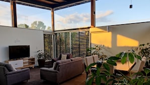 A spacious living area with a large flat-screen TV, comfortable seating, and a dining table.