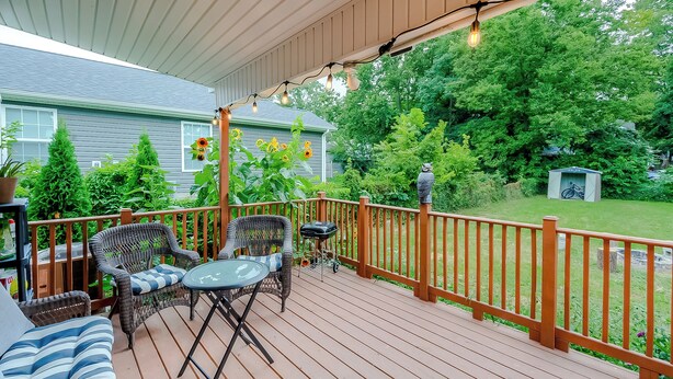 A covered deck with wicker furniture, a small table, and a grill. - Pet-Friendly Bluegrass Retreat w/ Fenced Yard (Georgetown)