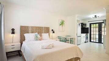 A bedroom with a bed, bedside tables, a desk, and a chair.