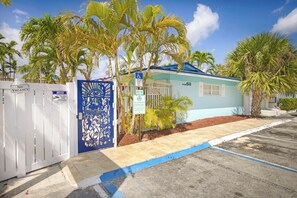 A small, single-story building with a blue roof and white walls, surrounded by palm trees. - La Mer Suites (Lauderdale-by-the-Sea)
