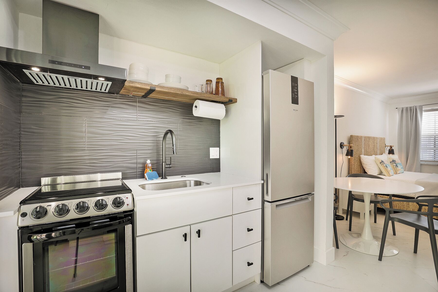 Une cuisine moderne équipée d’une cuisinière, d’un évier et d’un réfrigérateur.