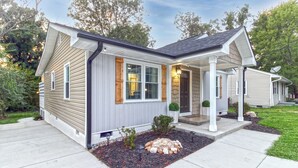 A single-story house with a covered porch, a stone fireplace, and a landscaped front yard. - Cozy 3bdrm 2ba mins from Downtown (Greensboro)