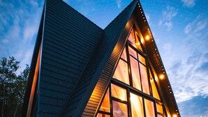Un bâtiment moderne de forme triangulaire, doté de grandes fenêtres et d’un jacuzzi situé au premier plan.