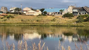 A lakeside view with houses and a dock. - Pacific City Riverfront Bungalow on Nestucca River! Dog friendly-Hot tub-Firepit (Pacific City)