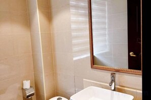 A bathroom with a white sink, a mirror, and a toilet. - Hotel Hunchun X (Hunchun)