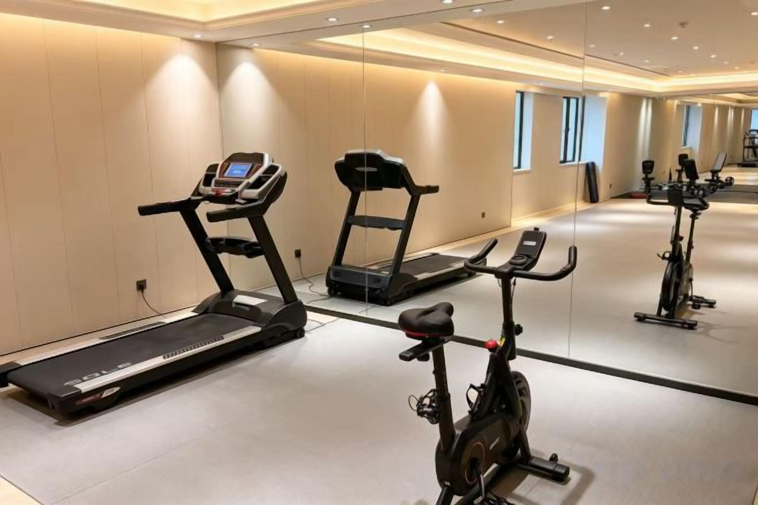 A gym with treadmills, an elliptical, and stationary bikes.
