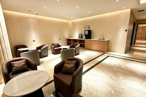 A hotel lobby with seating areas, a reception desk, and a marble floor. - Hotel Hunchun X (Hunchun)