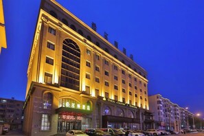 A multi-story hotel with a classic architectural design, featuring large windows and a prominent entrance. - Hotel Hunchun X (Hunchun)