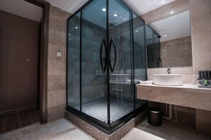 A modern bathroom with a glass-enclosed shower, a sink, and a large mirror. - Hotel Hunchun X (Hunchun)