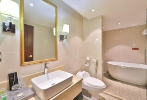 A modern bathroom with a large mirror, a rectangular sink, a toilet, and a freestanding bathtub. - Hotel Hunchun X (Hunchun)
