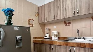 A kitchen with a refrigerator, a coffee maker, and a sink. - Casa Nawi (Cali)
