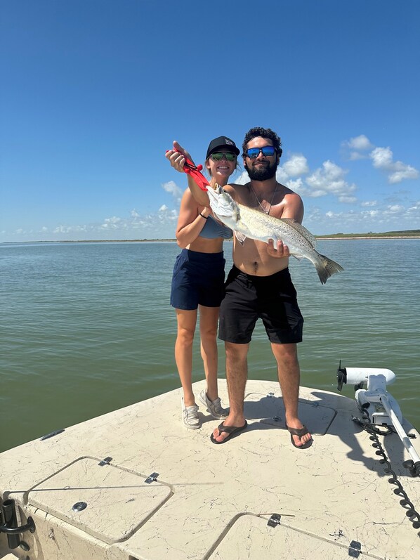 Two people on a boat holding a fish. - Make yourself at home in this spacious oasis! Welcome to The Laguna House! (Port Mansfield)