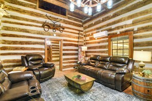 A log cabin interior with leather recliners, a wooden coffee table, and rustic decor. - Glasgow Getaway w/ Patio, Fireplace & Grill! (Glasgow)