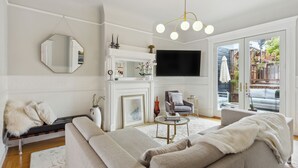 Una sala moderna con sofá, sillón y chimenea.