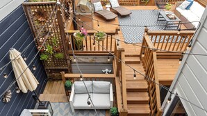 Terraza en la azotea con piso de madera, asientos exteriores y una chimenea.